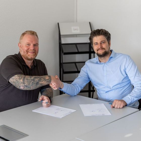 Handdruk naast het ondertekende distributiecontract